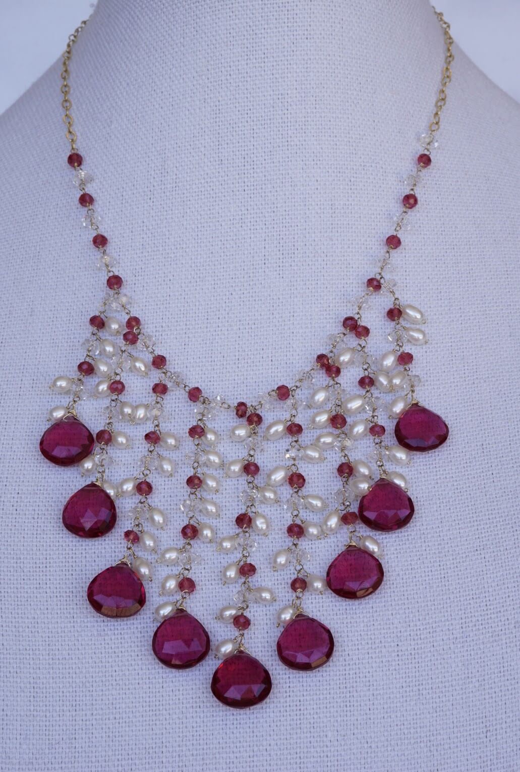 Rubelite, ruby and herkimer diamond necklace on display
